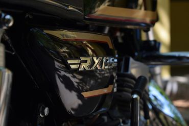 A close up of the side of a motorcycle with the word rx125 on it.